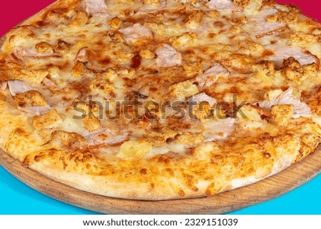 Pizza with bacon cheese and herbs on a wooden plate with cheese and cherry tomatoes. On a colored background. copy space