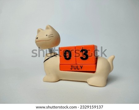 a unique july teddy cat calendar with blocks with the date and month written on it, on a white background