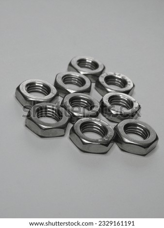 A handful of remarkably flat nuts, perfect for a variety of mechanical and DIY applications. Their sleek design allows for a flush and seamless fit, ensuring a secure and streamlined assembly