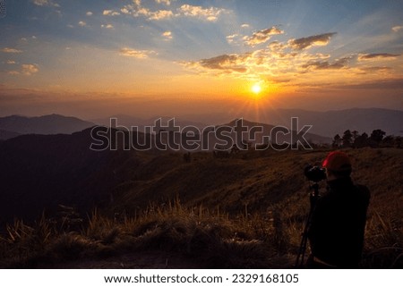 Travel photographer man taking nature of mountain landscape photographer taking landscape photos shooting slr camera on tripod. picture of sunset in mountains