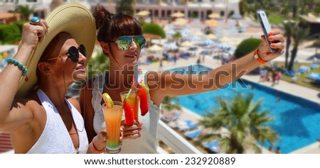 Two young women taking picture of themselves on vacation. Selfie