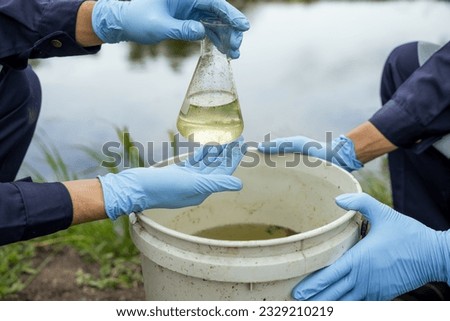 Environmental researchers investigate the condition of canal water for toxic spills, river waste water sampling, Asian researchers collect water samples in farmland for research and development. Royalty-Free Stock Photo #2329210219