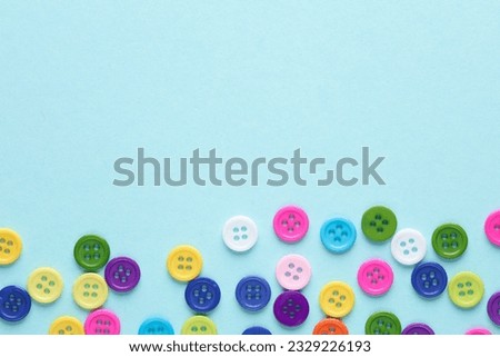 Many colored plastic buttons on a blue background. Copy space