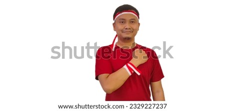 Indonesian man celebrate Indonesian independence day on 17 August isolated and showing respect gesture isolated on white background,man use red and white ribbon on head,indonesia independence concept