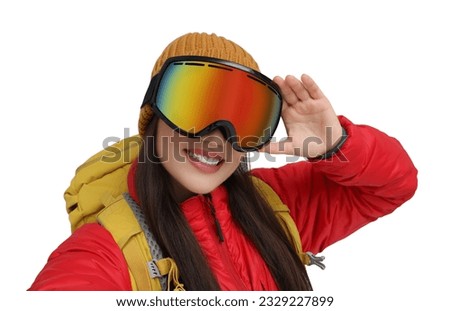 Smiling woman in ski goggles taking selfie on white background