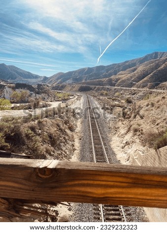 A train track cutting through a valley in the California desert