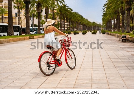 Woman riding bicycle on seaside boulevard 