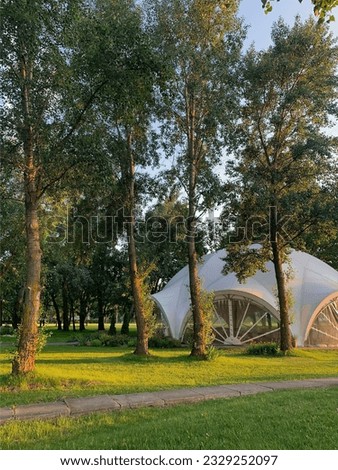 photo. round white house in the forest. bright green background. nature. golf. camp. trees and grass. Sun. canopy. park. landscape