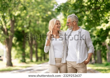 Romantic Senior Couple Walking Outdoors In Summer Park And Embracing, Loving Happy Mature Spouses Hugging And Smiling To Each Other, Cheerful Husband And Wife Enjoying Outside Walk, Copy Space Royalty-Free Stock Photo #2329252637