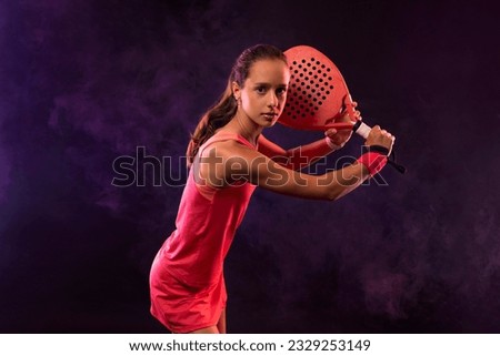 Junior padel tennis player with racket. Open day. Girl athlete with paddle racket on court. Sport concept. Download a high quality photo for the design of a sports app or social media publication.