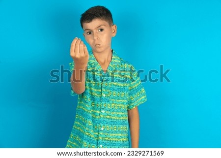 Little hispanic kid boy wearing green aztec shirt Doing Italian gesture with hand and fingers confident expression