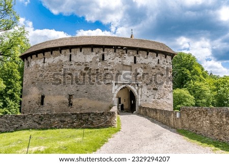 Mighty barbican at Pernstejn whose 3 m thick walls with crenels for light firearms and a machicolation protected a narrow way to the entrance  Royalty-Free Stock Photo #2329294207