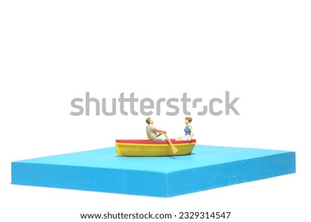Creative miniature people toy figure photography. Sticky notes installation. A couple dating on a boat at river lake sea. Isolated on white background. Image photo Royalty-Free Stock Photo #2329314547