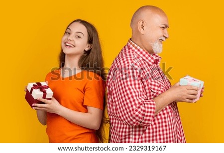 smiling kid and grandfather with present box for anniversary
