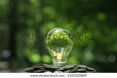 Sprouts and light bulbs on heap of silver coins, green business concept Finance and Investment for Sustainability and Carbon Credit