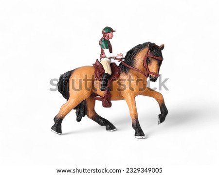 Plastic miniature brown horse animal with rider isolated on white