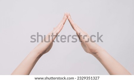 Home gesture. Roof symbol. Woman hands demonstrating housetop safe protection feeling isolated on gray free space background.