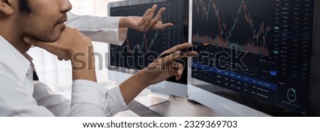 Group of traders discussing on office desk, monitoring stock market on monitor at office workplace. Businessman and broker analyzing stock graph together at stock trading company. Trailblazing