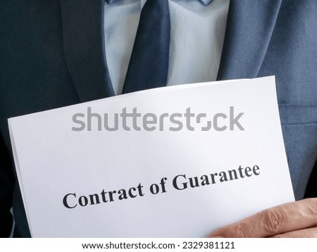 Man in suit is holding contract of guarantee. Royalty-Free Stock Photo #2329381121