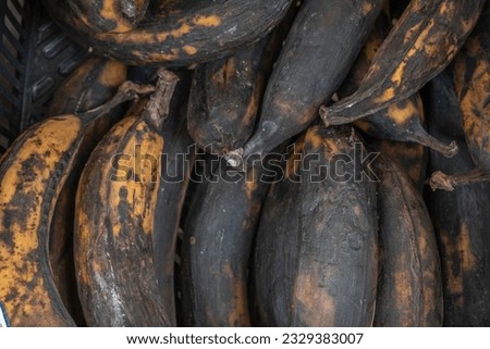 A close-up stock photo of old and overripe bananas on display in a retail store, highlighting their soft texture and brown spots.