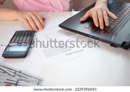 woman pays utility bills online on laptop, Energy bill showing electricity and gas, Heat and water utility bill for a house, Royalty-Free Stock Photo #2329396043