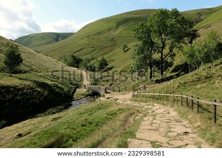 A packhorse bridge over the River Noe running through the upper Hope Valley, The Peak District, Derbyshire, UK. 