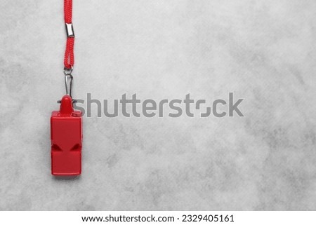 One red whistle with cord on light grey table, top view. Space for text Royalty-Free Stock Photo #2329405161