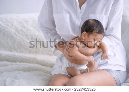 Portrait of newborn baby boy sitting on mother lap, caring love tenderness concept Royalty-Free Stock Photo #2329413325