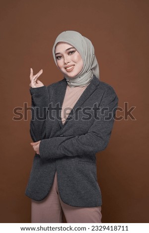 Portrait of hijab girl smiling to the camera. Pretty muslim girl. Beautiful asian muslimah woman model posing on dark background studio. Stylish Muslim female fashion lifestyle  concept.