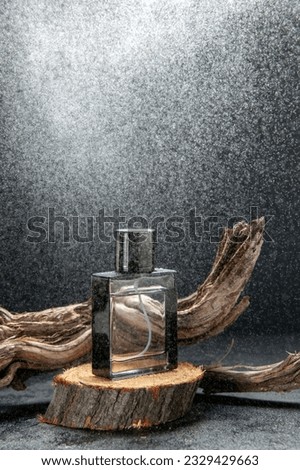 Side view of parfum on wooden cutting board and tree branch on light on dark background with free space