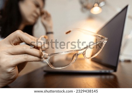 Tired female holding bad spectacles,problem of visual acuity test or inaccurate eye measurement error,woman wear non-standard eyeglasses suffers eye strain,blurred vision,prescription glasses concept Royalty-Free Stock Photo #2329438145