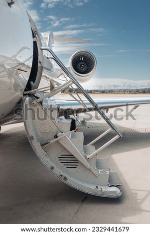 Open airstairs of a private jet at the airport. Luxury business jet  Royalty-Free Stock Photo #2329441679