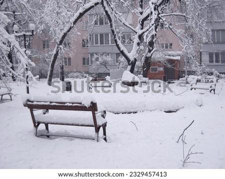             winter cityscape with a bench in the foreground
                   