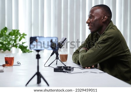 Smiling podcaster listening to his guest answering question