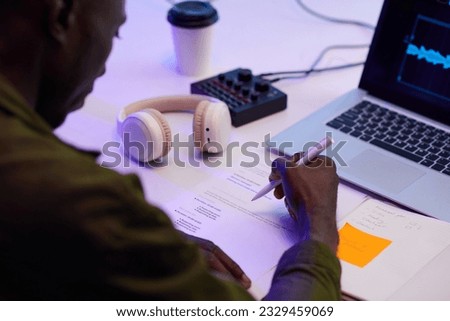 Blogger checking scenario when editing podcast in his studio