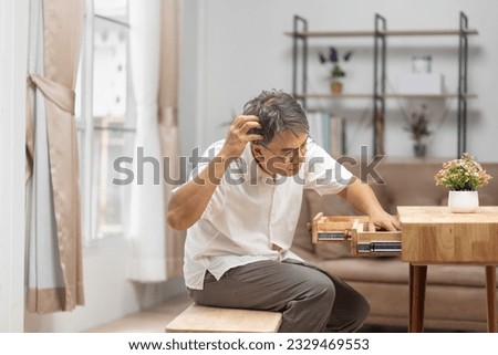 Asian older man finding something that he forgot it in drawers. Royalty-Free Stock Photo #2329469553