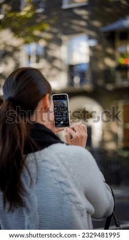 Asian Woman taking photo with her mobile phone in london