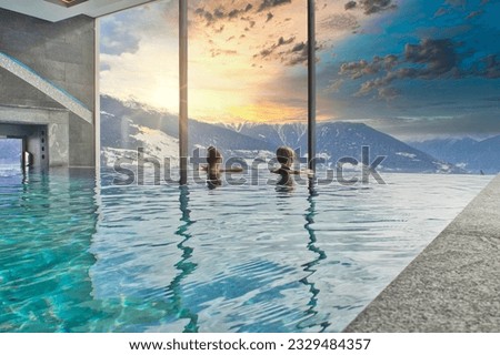 Women enjoying the panoramic view from the pool in the alps
