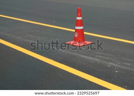 Orange trafic cone on the parking lot, safety cone, rubber cone