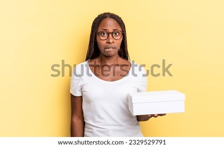 looking puzzled and confused, biting lip with a nervous gesture, not knowing the answer to the problem and holding an empty box
