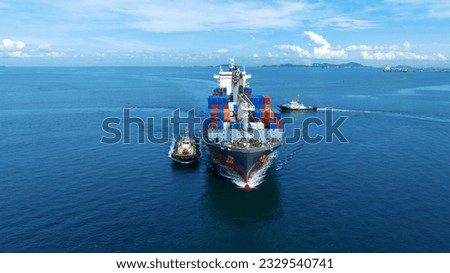 Aerial front view of cargo ship carrying container and running with tug boat for import export goods from cargo yard port to custom ocean concept freight shipping by ship . Royalty-Free Stock Photo #2329540741