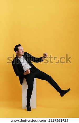Photo of attractive rich successful businessman wear stylish clothes hold plastic card demonstrates nfc isolated on yellow color background