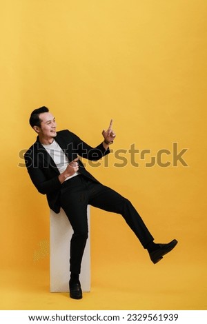Photo of attractive rich successful businessman wear stylish clothes hold plastic card demonstrates nfc isolated on yellow color background