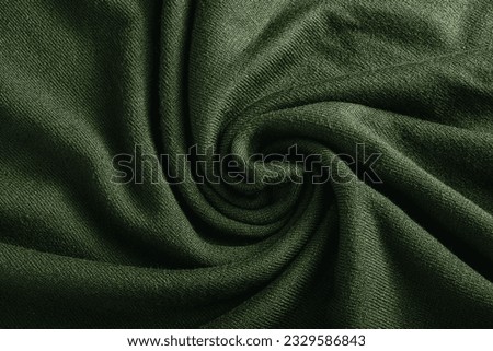Dark green cashmere fabric close up. Textile background. Folds on natural woolen fabric. Royalty-Free Stock Photo #2329586843