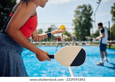 Unrecognizable African American woman serving the ball while playing mixed doubles in pickleball. Royalty-Free Stock Photo #2329591843