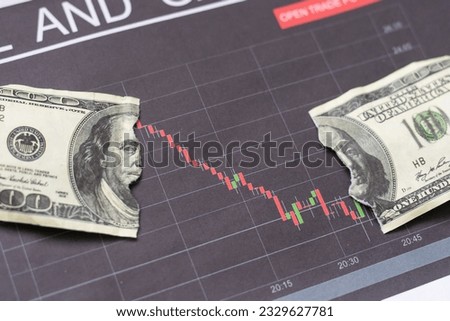 US dollar banknotes stacks over digital screen with exchange chart, depreciation and volatility concept, directly above view Royalty-Free Stock Photo #2329627781