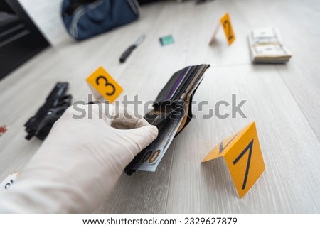 Close up on hands of unknown man forensic police investigator collecting evidence in the plastic bag at the crime scene investigation Royalty-Free Stock Photo #2329627879