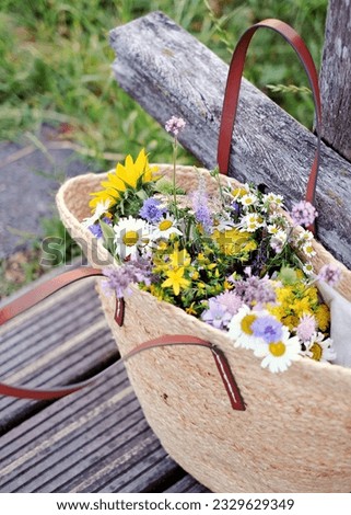 French style basket full of various fresh wild flowers from market
