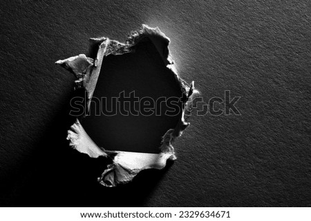 Black and white background of torn paper with hole Royalty-Free Stock Photo #2329634671