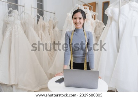 Happy smiling Asian creative fashion designer is working owner working in her tailor shop. Woman creating new clothes collection concept